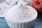 Sweet fructose powder and apple on light blue wooden table, closeup