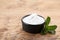 Sweet fructose powder and mint leaves on wooden table