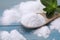 Sweet fructose powder, spoon and mint leaves on light blue wooden table, closeup