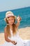 Sweet girl on beach showing shell.