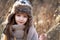 Sweet girl in a cap with the deer in autumn in a field of dry grass