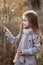 Sweet girl in a cap with the deer in autumn in a field of dry grass