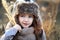 Sweet girl in a cap with the deer in autumn in a field of dry grass