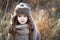 Sweet girl in a cap with the deer in autumn in a field of dry grass