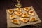 Sweet gomentashi cookies for the holiday of Purim on the board are laid out on a linen napkin.