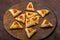 Sweet gomentashi cookies for the Jewish holiday of Purim on a chalkboard are laid out in the form of Magen David on the