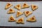 Sweet gomentashi cookies for the Purim holiday on a chalkboard laid out on a gray napkin.