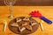 Sweet gomentashi cookies on a wooden board next to a clapper for the Purim holiday