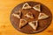 Sweet gomentashi cookies on a wooden board in the shape of a Star of David for a Purim treat