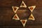 Sweet gometashi cookies for Purim laid out on a wooden table in the form of Magen David.