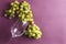 Sweet grapes, glasswine on violet background.Top view of glassware and tasty fruit