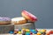 Sweet holiday donuts on wooden forest stands multi-colored chocolate little candies on a gray background close-up