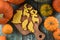 Sweet homemade animal shaped cookies: bear, moose, wolf on wooden board surrounded with raw bright orange pumpkins