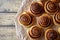 Sweet Homemade christmas baking. Cinnamon rolls buns with cocoa filling on parchment paper. Kanelbulle swedish dessert.