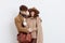 a sweet, joyful, pleasant stylish couple stands on a white background in autumn coats and gently hug each other