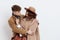 a sweet, joyful, pleasant stylish couple stands on a white background in autumn coats and gently hug each other, a woman
