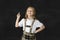 Sweet junior blond schoolgirl smiling happy in front of school classroom blackboard