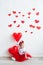 Sweet kid with red heart. Happy little girl with red balloon at a blank brick wall. Wedding, Valentine concept