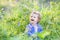 Sweet laughing baby girl in a purple sweater in meadow