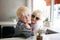 Sweet Little Child Hugging his Baby Sister at A Coffee House Cafe