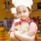 Sweet little cute child girl is ready learn to cook. Humorous ph