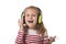 Sweet little girl with blonde hair listening to music with headphones and mobile phone singing and dancing happy