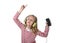 Sweet little girl with blonde hair listening to music with headphones and mobile phone singing and dancing happy