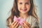 Sweet little girl eating pink donut