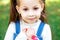 Sweet little girl outdoors with curly hair in two long tails, closeup portret.