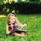 Sweet little girl reading book in a summer park