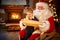 Sweet little girl in Santa Claus lap choosing her present