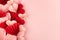 Sweet love background for wedding or Valentine day with heap many gentle pink and red paper hearts on pink backdrop, sideways.
