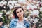 Sweet lovely girl standing on soft background Magnolia blossoming flowers