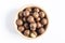 Sweet macadamia nut in a brown dish on a light background top view