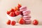 Sweet macaron with strawberries on a neutral background.