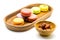 Sweet macarons in wooden tray and almonds in wooden bowl