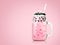 Sweet milk tea with bubbles in clear glass and drinking straws on pink background. Thai milk with black pearls