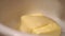Sweet molasses is poured onto a piece of butter.close-up
