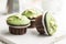 Sweet muffins with pistachio icing. Sweet dessert on kitchen table