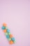 Sweet multicolored marshmallows on a pastel pink background. Delicious soft sweets. View from above.