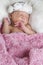 Sweet newborn girl wrapped in a pink blanket