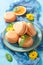 Sweet orange macaroons on table and yellow flowers