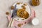 Sweet pancakes with boiled condensed milk and walnuts on plate with fork and knife, milk in glass and caramel in jar near, at