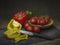 Sweet peppers and red tomatoes, still life. Light painting. With retro knife and slate rustic background.
