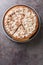 Sweet pie with a filling based on rice pudding topped with whipped cream and chocolate chips close-up in a plate. Vertical top