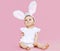 Sweet pink cute baby sitting in costume easter bunny