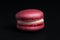 Sweet pink macaroon isolated on black