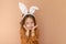A sweet, pleasant little girl dressed up in an Easter bunny costume