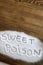 SWEET POISON written on pile of sugar