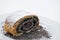 Sweet poppy strudel with powder sugar on white plate, product photography for bakery or patisserie